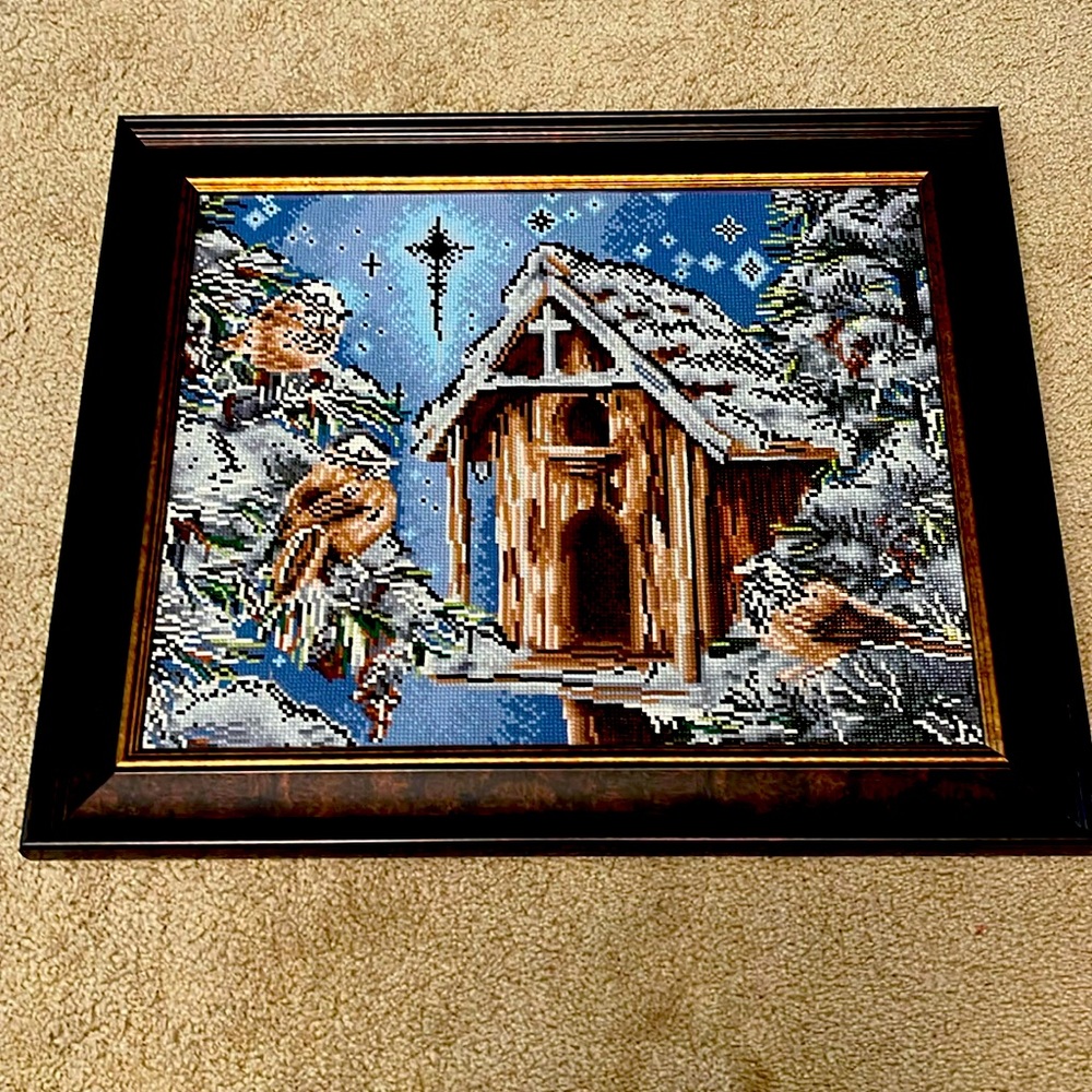 A cross bird house with winter scene, and three birds